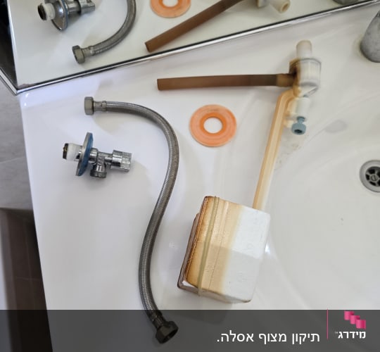 חלקי אינסטלציה על כיור בחדר אמבטיה